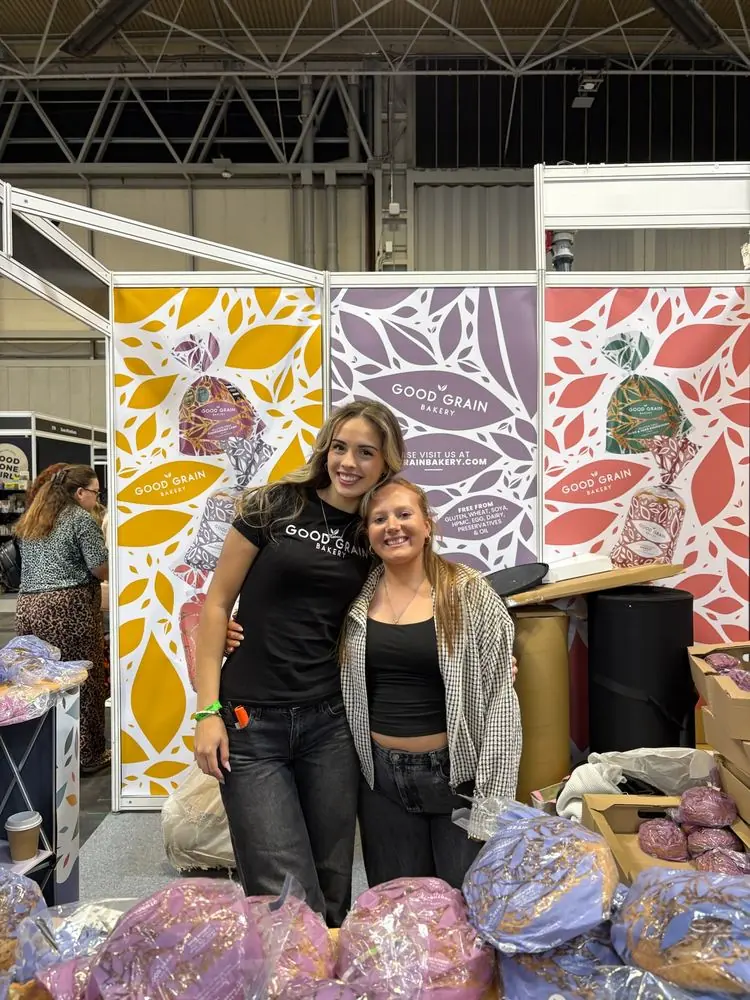 Katrina and a colleague in front of the Good Grain Bakery stand at a food show