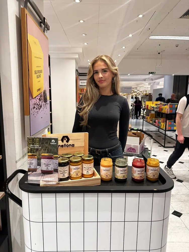 Katrina at a Mellona honey sampling stand in a department store